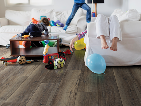 kids playing in living room with wood-look luxury vinyl flooring from A Touch Of Magic Flooring in Emerald Isle, NC